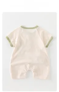 Vue détaillée du barboteuse bébé montrant le tissu crème et les bords-côtes verts