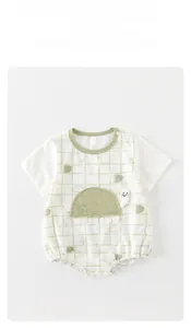 Detail shot of baby cotton romper with green checkered pattern and turtle embroidery