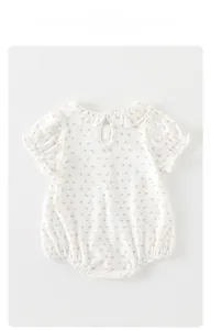 Détail d'une barboteuse fleurie pour bébé fille avec col à volants et manches bouffantes