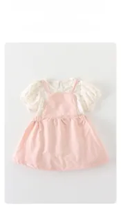 Detailed view of baby girl floral shirt and pink overall dress set with soft cotton texture