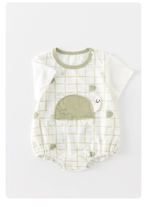 Detail showing soft white cotton baby bodysuit with green checkered trim and turtle embroidery