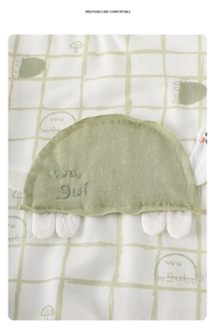 Detail of baby romper featuring a green turtle applique and breathable cotton fabric