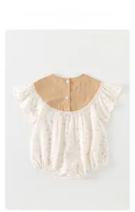 Detail of floral baby romper featuring bunny patterns and delicate lace ruffles on sleeves