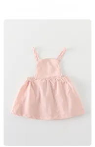 Detail of light pink baby suspender skirt featuring delicate white lace trim and elastic waist