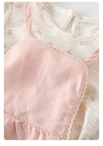 Detail of baby floral bodysuit with waffle texture and pink lace strap dress