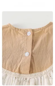 Detail of baby romper with white lace trim, wooden buttons, and floral rabbit pattern fabric