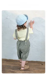 Rückansicht von Baby-Sommeroutfit mit grüner Karo-Latzhose und gelbem T-Shirt