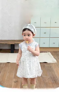 Detailed close-up of girls floral sleeveless summer dress with matching lace headband