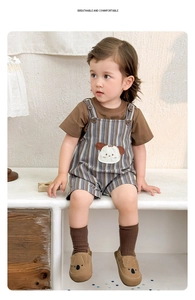 Detail of baby summer set with brown t-shirt and striped overalls featuring dog patch