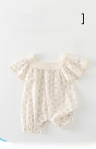 Détail d'un barboteuse à fleurs pour bébé avec col en dentelle et broderie ajourée