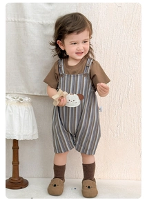 Detail of infant summer set featuring striped overalls with a cute cartoon dog patch