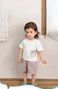 Détail d'une tenue d'été pour bébé avec T-shirt blanc imprimé et short cargo lilas