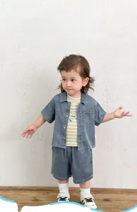Détail d'un ensemble trois pièces en denim pour garçon avec t-shirt rayé et chemise
