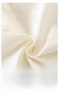 Zoom sur le tissu en tricot blanc crème doux et respirant pour vêtements d'été bébé