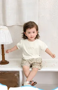 Dettaglio completo di set estivo per neonato con t-shirt orsetto e pantaloncini leopardati