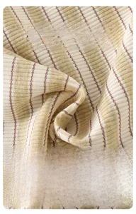 Gros plan sur un tricot côtelé doux à rayures beige, vert et marron pour habits de bébé