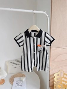 Detail of baby polo romper featuring vertical black stripes and a soft cotton polo collar