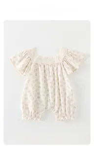 Détail d'une barboteuse fleurie pour bébé fille avec col en dentelle blanche et volants