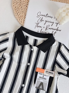 Close-up of baby striped polo romper featuring a contrast collar and chic chest pocket
