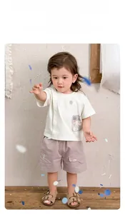 Détail d'un ensemble d'été garçon avec t-shirt blanc et short en coton lilas clair
