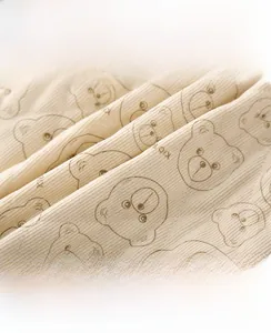 Close-up of ribbed cotton baby romper fabric with cute cartoon bear print and soft texture