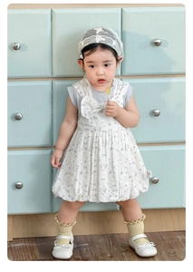 Detail of baby girl floral sundress featuring a large bow and ruffled lantern hemline