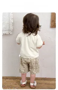 Dettaglio dell'etichetta di lavaggio della maglietta e pantaloncini leopardati da bimbo