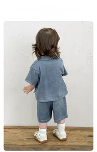 Vue arrière d'un enfant portant un ensemble chemise et short en denim bleu clair lavé