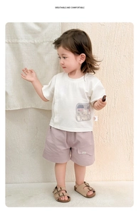 Détail du t-shirt blanc en coton avec poche cartoon et short décontracté violet