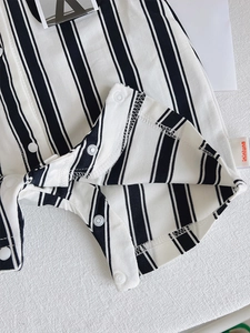 Detail of baby striped romper featuring premium white snap buttons for easy diaper changes