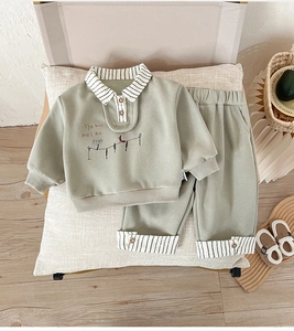 Detail of kids casual cotton set with bird embroidery and striped cuffs on polo sweatshirt