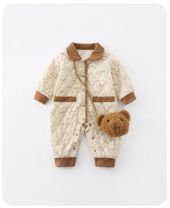 Detail of quilted baby romper featuring corduroy trim and cute bear print design