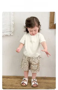 Dettaglio maglietta neonato con orsetto e pantaloncini leopardati con tasche laterali capienti