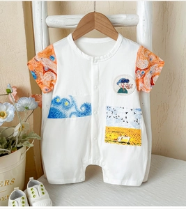 Detail of baby short sleeve romper showing artistic patchwork and soft cotton texture