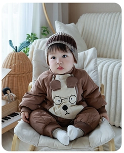 Detailed view of baby quilted romper featuring a cute cartoon bear design and striped knit hat