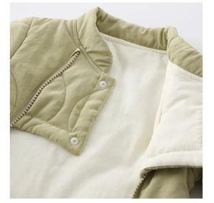 Detail view of quilted baby romper with dual zippers and warm fleece lining in sage green