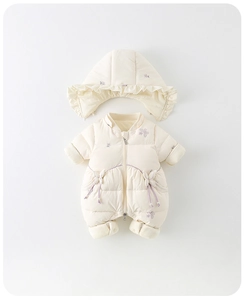 Détail d'une barboteuse matelassée crème pour bébé avec broderie florale et capuche