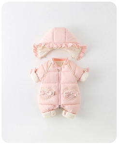 Close-up of pink quilted baby snowsuit featuring heart pockets and bow detailing