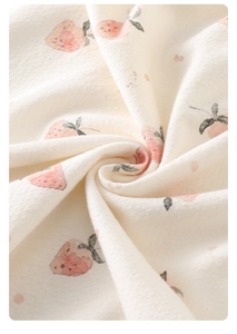 Macro shot of soft cotton fabric texture featuring cute pink strawberry prints on baby romper