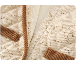 Close-up of quilted beige corduroy baby romper with kid bear print and button details