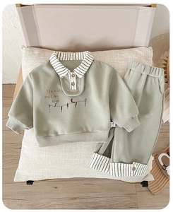 Detail of boys green casual two-piece set with bird print and striped cuffs