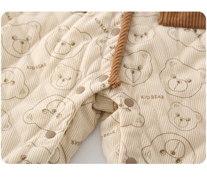 Macro shot of quilted corduroy fabric with bear print and snap buttons on baby romper