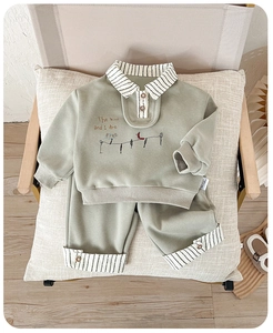 Close-up of sage green boys' two-piece set with polo collar and striped embroidery detail