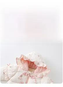 Close-up of baby winter romper with floral embroidery and ruffle hood detail