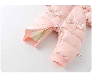 Close-up of pink quilted baby romper with bow accents and pearl edge detailing