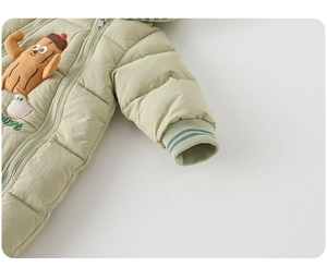 Detailed close-up of light green quilted baby romper with cartoon patch and ribbed cuffs