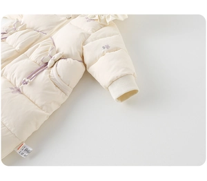 Détail d'une barboteuse d'hiver pour bébé avec broderie florale et texture du tissu