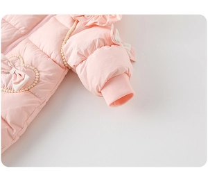 Detail of pink baby winter romper featuring heart beads, bow decoration and ruffled shoulders