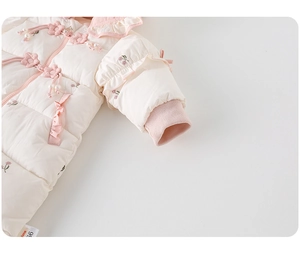 Close-up of baby winter romper with floral embroidery and elegant pearl flower buttons