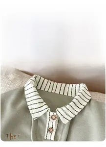 Detail of green knit polo shirt featuring striped collar and delicate texture